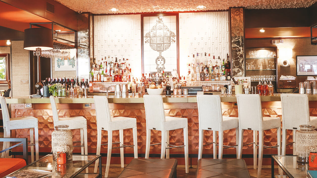 Bar with copper accents and risers of high-end liquors